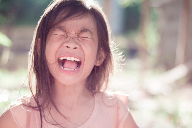 写真 閉じた目で外で叫んでいる女の子