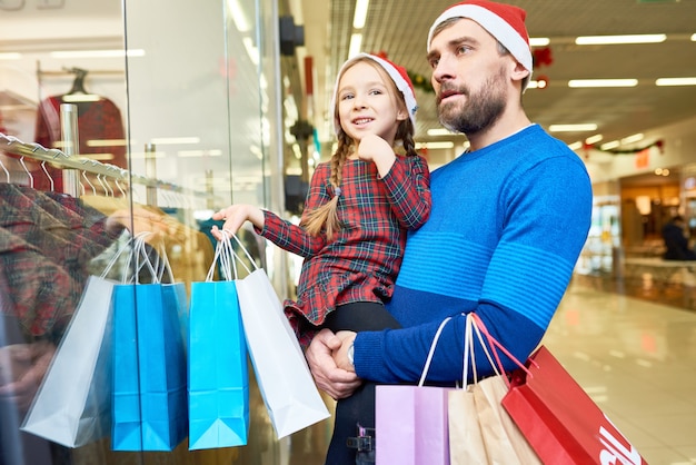 Girl with father shopping before Christmas holiday