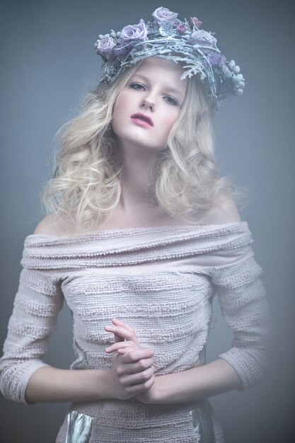 ロシア風のドレスを着た彼女の頭に花を持つ少女スタジオで撮影した写真
