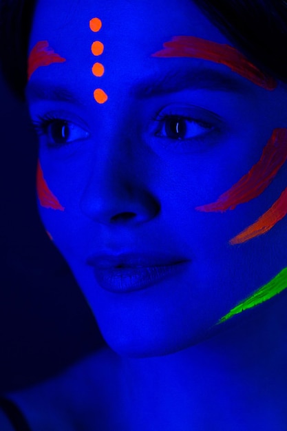 Girl with fluorescent make up on her face and chest