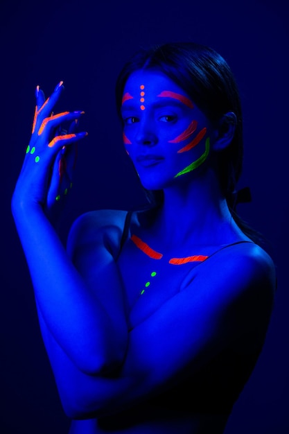 Girl with fluorescent make up on her face and chest