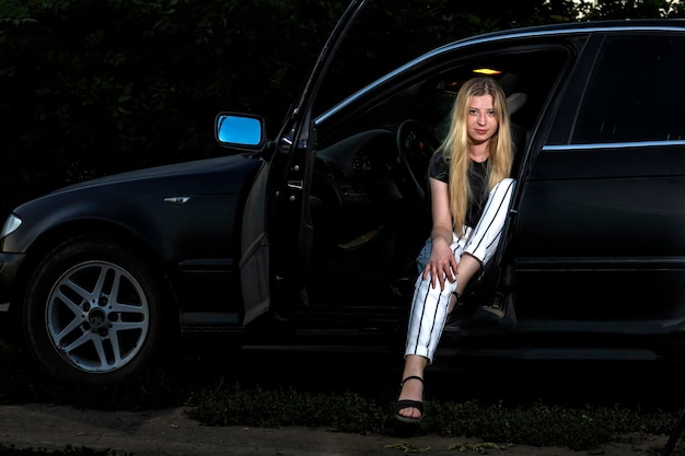 Photo a girl with freckles in a black car