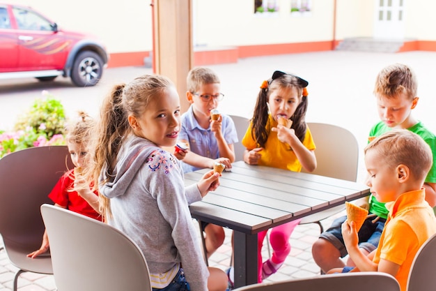 Ragazza con amici che mangiano il gelato in un bar all'aperto per il suo compleanno