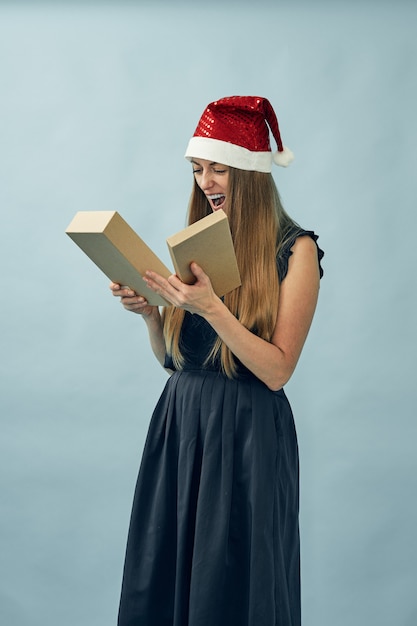 Girl with a gift box in her hands and wearing a santa claus hat