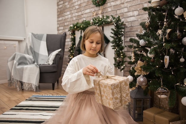 girl with a gift at the christmas tree