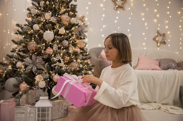 Girl with a gift at the Christmas tree