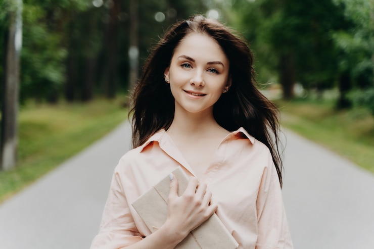 Фотография девушка с подарком гуляет в парке