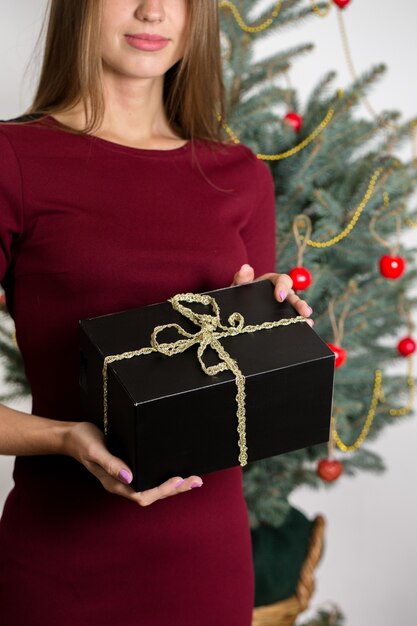 Girl with gifts on the background of a christmas tree