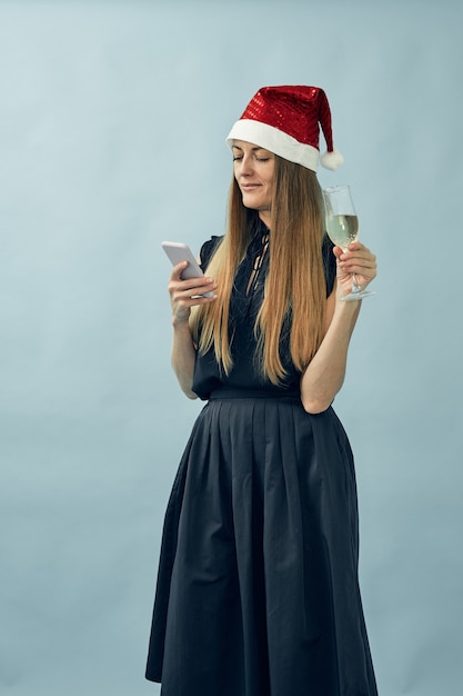 Girl with a glass of champagne and a santa claus hat