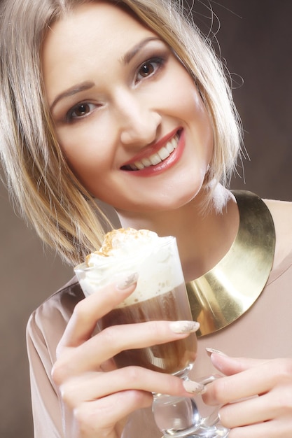 Foto ragazza con un bicchiere di caffè con crema