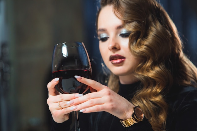 Ragazza con un bicchiere di vino rosso in un ristorante