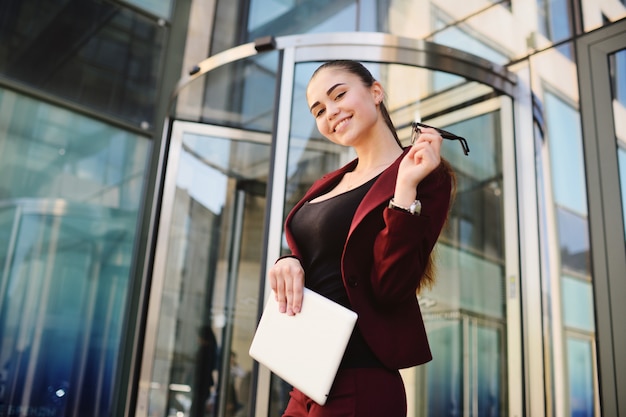 Girl with glasses on the background of a glass office building