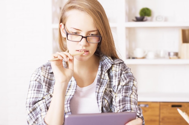 Ragazza con gli occhiali utilizzando tablet