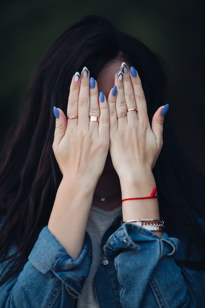 Girl with gorgeous dark long hair hiding face by arms