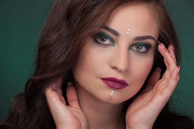 Девушка с зелеными тенями для век макияж лица камни кристаллы