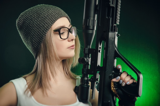 La ragazza con una pistola in posa su uno sfondo nero ( cannocchiale da cecchino )