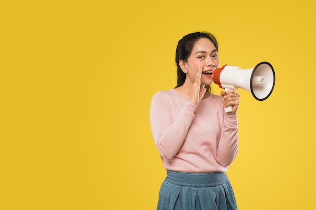 Girl with hands beside mouth making announcement using megaphone