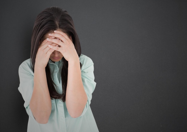 Girl with hands on face against grey wall