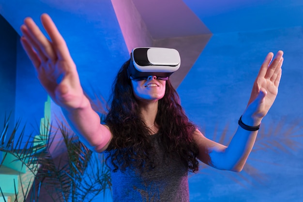 Фото Девушка с поднятыми руками в очках виртуальной реальности