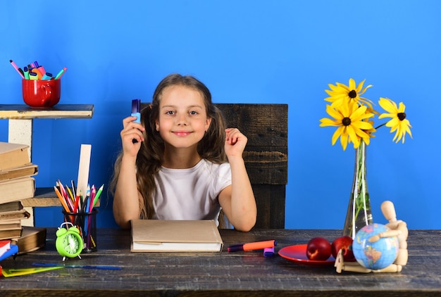 Girl with happy face holds blue marker