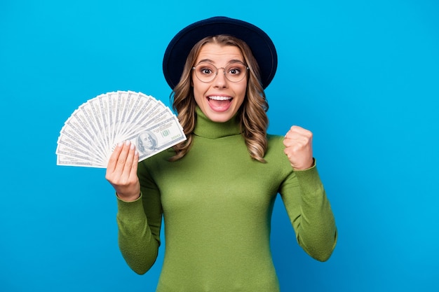 girl with hat and glasses holding fan of money