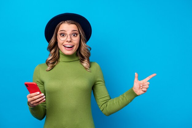 Ragazza con cappello e occhiali tenendo il telefono