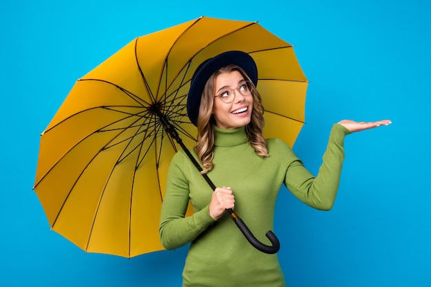 girl with hat and glasses holding umbrella