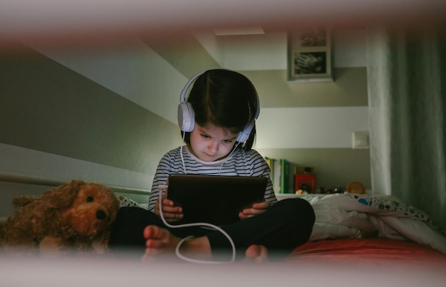 Girl with headphones looking at the tablet