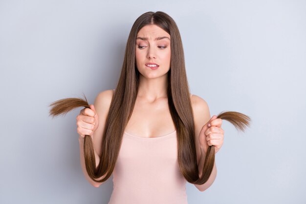 girl with healthy hair in her hands isolated on grey