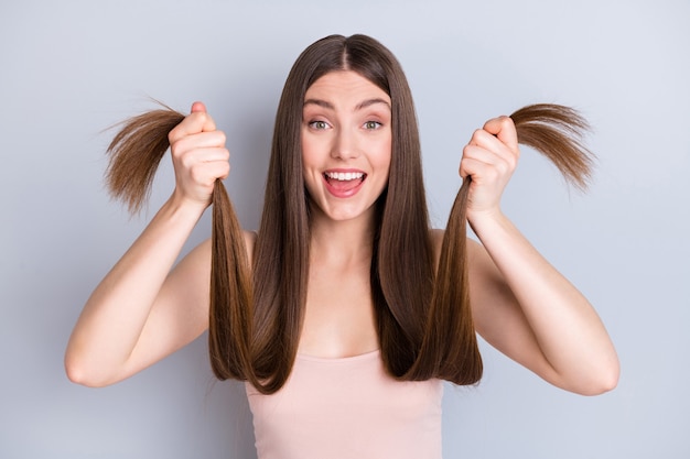 girl with healthy hair in her hands isolated on grey