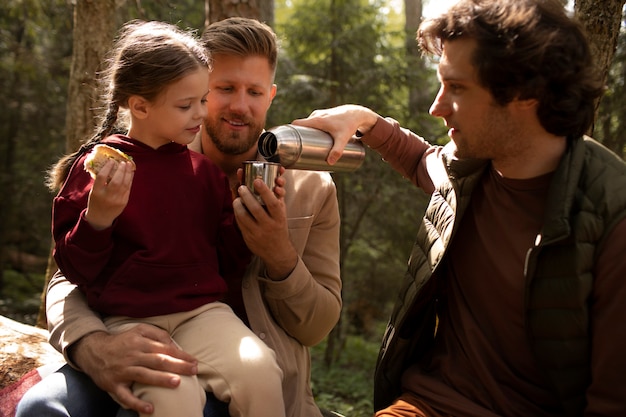 Foto ragazza con i suoi papà che si gode il viaggio di famiglia