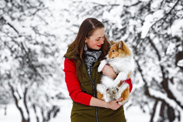 Girl with her dog in winter park.