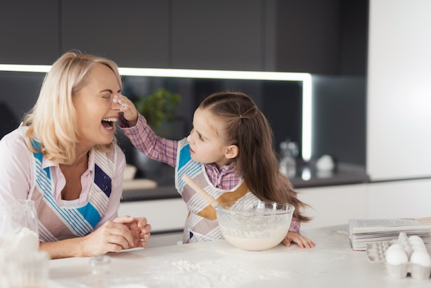 A girl with her grandmother cooks a homemade cake.