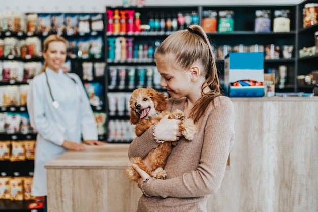 写真 獣医で彼女のプードルの子犬を持つ少女。