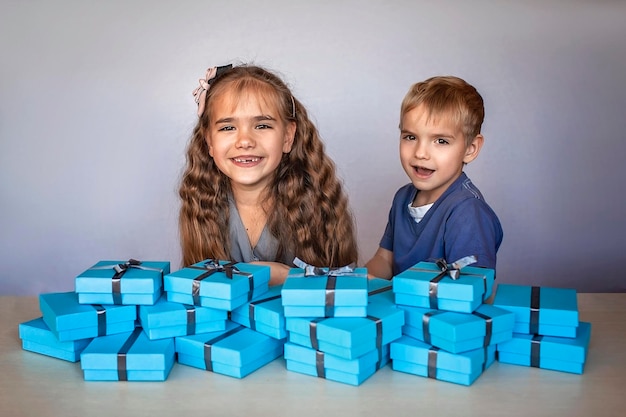 Girl with her smaller brother near a huge pile of gift boxes