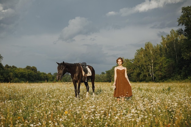 A girl with a horse a brown dress a man in nature with an animal