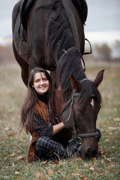 自然の中で馬を持った少女、動物と一緒に秋の散歩