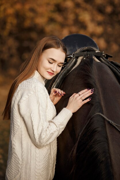 A girl with a horse in nature, an autumn walk with an animal