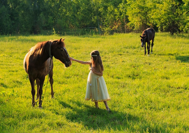 Girl with a horse in summer