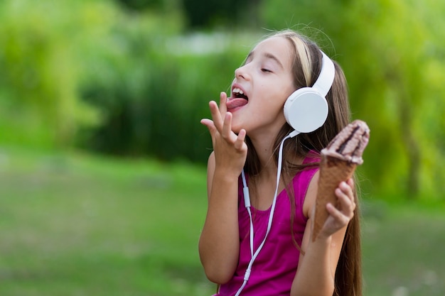 Girl with ice cream licking fingers