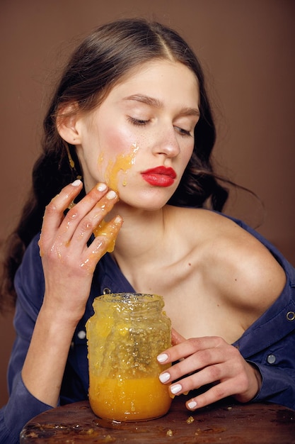 Girl with jar of honey Healthy food concept diet dessert Beautiful woman with honey on her face Healthy perfect skin Honey treatment