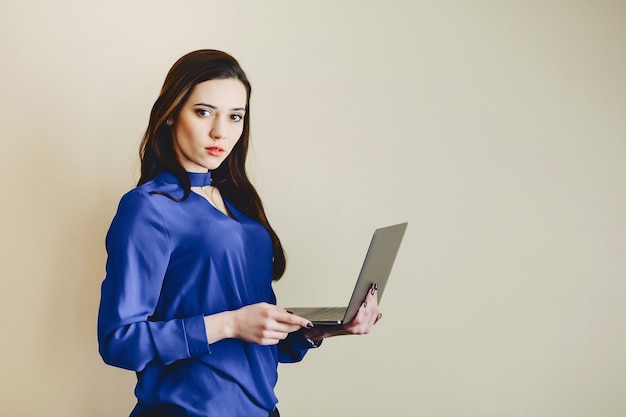 Girl with laptop on background of wall