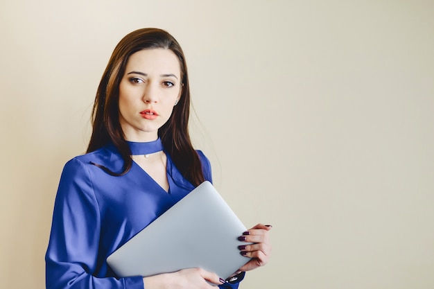 Girl with laptop on background of wall