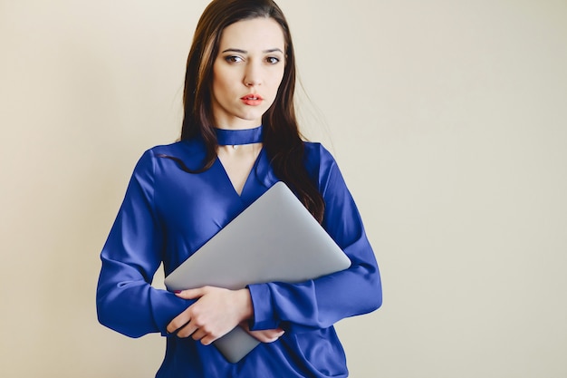 Girl with laptop on background of wall