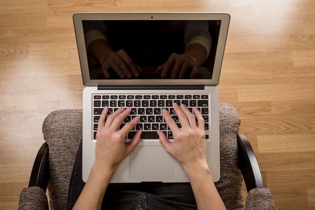 The girl with the laptop sits on a chair to houses