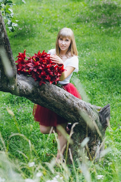 紫色のユリの大きな花束を持つ少女