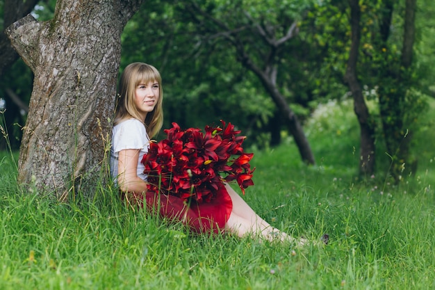 紫色のユリの大きな花束を持つ少女