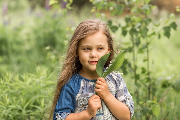 girl with lily of the valley in nature