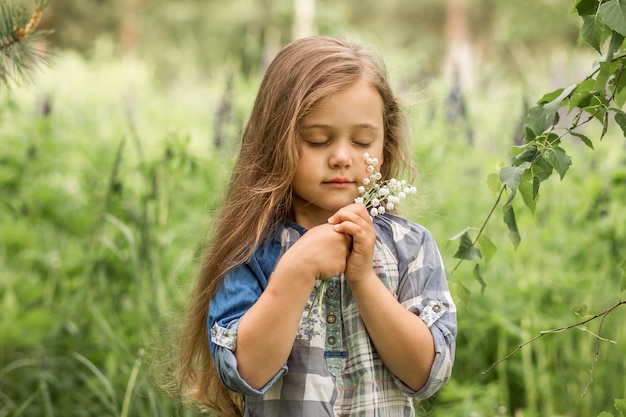 girl with lily of the valley in nature