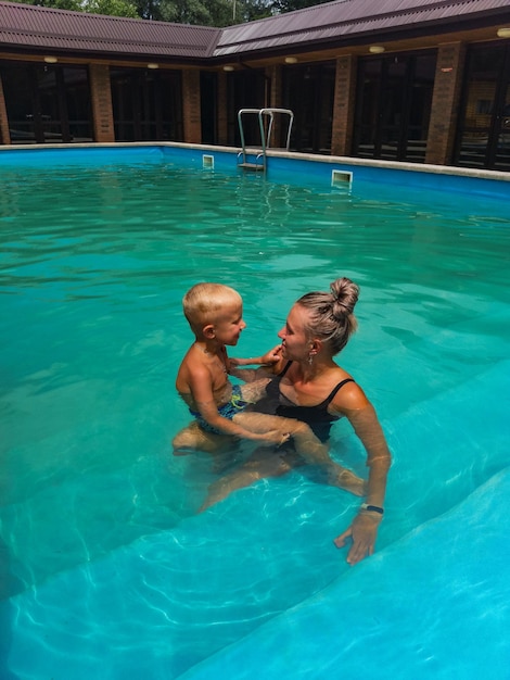 A girl with a little boy in a pool with thermal water in Adygea Hot spring Russia 2021